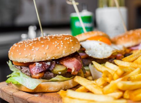 Šťavnatý domáci burger, v ktorom je na cheddare a pod slaninkou, oštiepkom a volským okom položené zomleté mäso ugrilované na horúcom rošte.