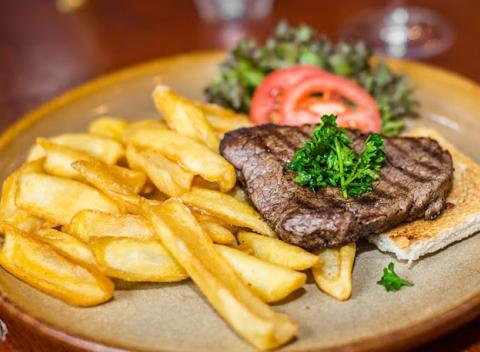 Hovädzí steak Filet Mignon z pravej hovädzej sviečkovice s omáčkou a fantastickými hranolkami v Moose Pub & Grill. 
