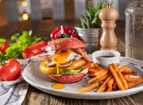 Red burger s batatovými hranolkami a nápojom v reštaurácii Le Papillon.